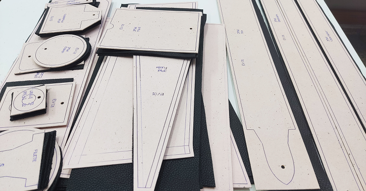 Collection of leather cutting templates and patterns neatly arranged on a worktable.