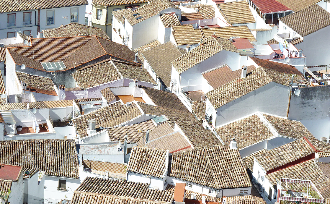 Aerial view of traditional white houses with tiled roofs in Ubrique, a picturesque town in southern Spain.